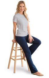 Model sitting on a stool wearing Bootcut Indigo PajamaJeans with a Gray T-shirt and Tan flats. image number 2
